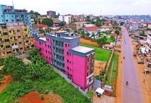 un edificio rosa en medio de una ciudad en Le meublé des voyageurs en Yaundé
