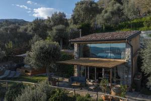 una piccola casa con una grande vetrata di Chalet Montecucco with lake view and jacuzzi a Gardone Riviera