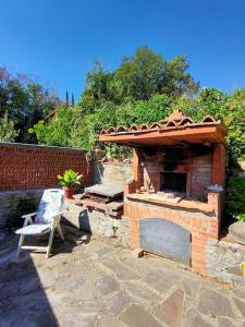 uma lareira de tijolos com uma cadeira num quintal em CASA DI NAT em Pratolino