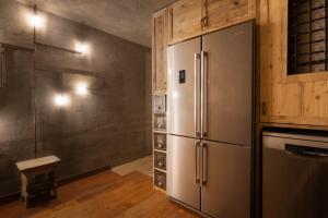 una cucina con un frigorifero in acciaio inossidabile in una stanza di Chalet Montecucco with lake view and jacuzzi a Gardone Riviera