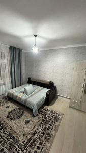 een slaapkamer met een bed met een tapijt op de vloer bij Avocado in Bisjkek
