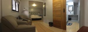 uma sala de estar com um sofá e uma cama num quarto em Sunbloom Beachfront Hotel and Restaurant em Sinabacan