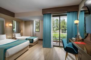 a hotel room with a bed and a desk at Kaya Side in Side