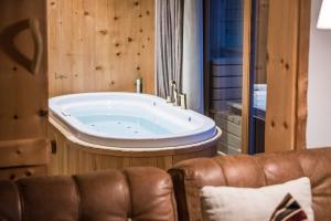 a large tub in a room with a leather couch at Alma Apartments in Luson +45 photos