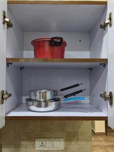 a pan and utensils on a shelf in a kitchen at Excellent Home Away from Home! in Noida