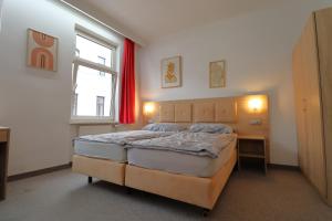 sypialnia z dużym łóżkiem i oknem w obiekcie Golden’s Apart-Hotel w Wiedniu