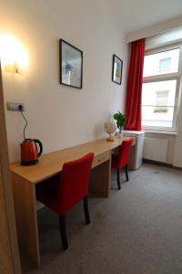 a room with a desk and two red chairs at Golden’s Apart-Hotel in Vienna