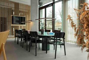 a dining room with a table and black chairs at Zleep Hotel Hillerød in Hillerød