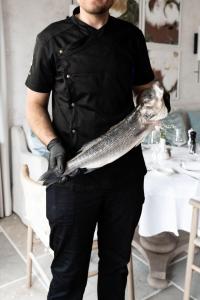 a man holding a fish in his hands at Saints Hills Cantina in Višnjan