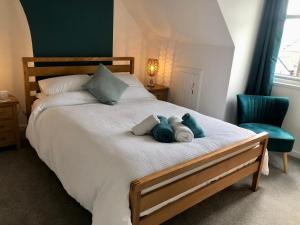 a bedroom with a bed with two stuffed animals on it at Knoll Guest House in Cromer