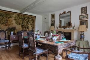 uma sala de jantar com uma mesa, cadeiras e um espelho em 7 Bedrooms Manor Farmhouse with heated pool em Cirencester
