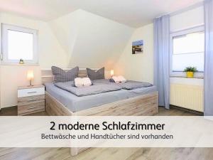 a bedroom with a bed and two windows at strandnahe Familien-Oase mit Kinderbuggy in Bensersiel