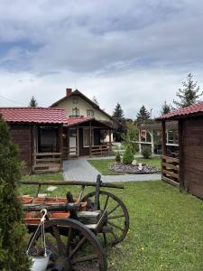 a yard with a house and a wooden wagon at Hotel Intim in Rădăuţi