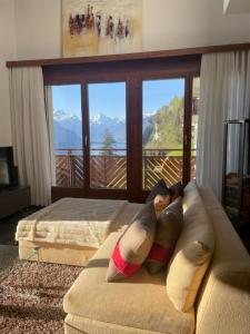 a living room with a couch with a view of mountains at LakeHill72 in Seelisberg