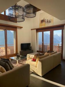 ein Wohnzimmer mit 2 Sofas und einem Balkon in der Unterkunft LakeHill72 in Seelisberg