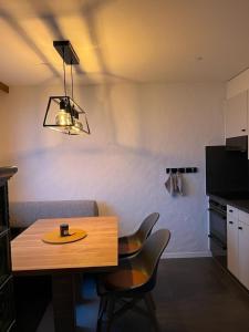 a table and chairs in a room with a kitchen at LakeHill72 in Seelisberg