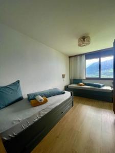 a bedroom with two beds and a large window at LakeHill72 in Seelisberg