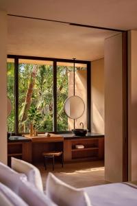 een slaapkamer met een groot raam en een spiegel bij One&Only Mandarina in Lo de Marcos