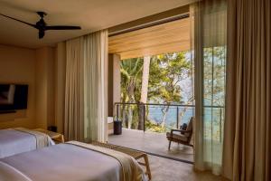 a bedroom with a bed and a balcony with a view at One&Only Mandarina in Lo de Marcos