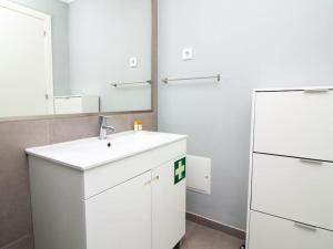 La salle de bains blanche est pourvue d'un lavabo et d'un miroir. dans l'établissement Old Town II Apartment - Top Location & Downtown Albufeira, à Albufeira