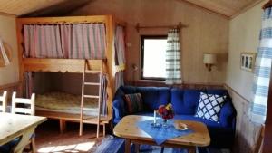 a living room with a couch and a bunk bed at Kleines Ferienhaus auf Naturgrundstück in Seenähe - b48624 in Sollerön