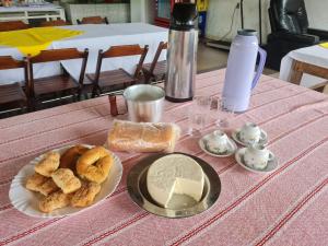 a table with a plate of bread and cheese on it at Pousada Vista Serra PRADOS MG in Prados