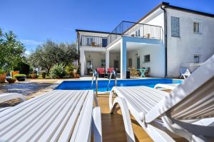 une villa avec une piscine et une maison dans l'établissement Apartments Siparis with Pool, à Zambratija