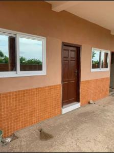 uma casa a ser remodelada com uma porta e janelas em Oyibi Sasaabi Apartment em Lateman
