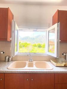 a kitchen with a large sink and a window at Stone House in the foothills of Taygetos in Xirokámbion