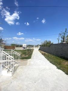 a walkway with a fence and a truck in a field at Stone House in the foothills of Taygetos in Xirokámbion