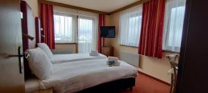 een hotelkamer met 2 bedden en een televisie bij Hotel Buckelhof in See