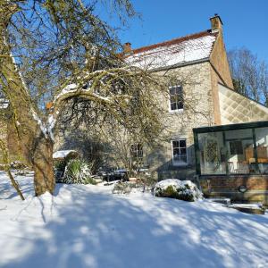 a house with snow in front of it at Au fil des champs in Berzée