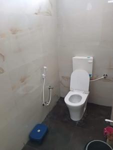 a bathroom with a white toilet and a blue scale at OYO Hotel Orvin In in Jabalpur