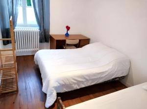 Un dormitorio con 2 camas y una mesa con un jarrón. en Appartement de 2 chambres avec jardin clos et wifi a Chateaudun, en Châteaudun