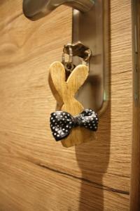 a wooden key chain with a bow tie on a door at Waldzeit Lodge - Ferienwohnung Hase in NeuhÃ¼tten