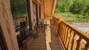 a porch of a cabin with chairs and a fireplace at Waldzeit Lodge - Ferienwohnung Eule in NeuhÃ¼tten