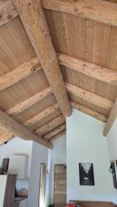 um quarto com tectos de madeira e vigas de madeira em Waldzeit Lodge - Ferienwohnung Eule em NeuhÃ¼tten