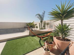 a patio with a hammock and plants on a balcony at Casa Biota in Sagres
