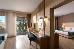 a hotel room with a bed and a desk with a mirror at Kaya Side in Side
