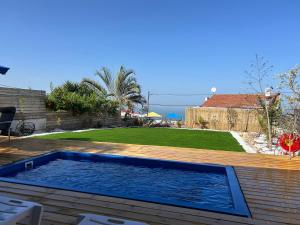 a swimming pool on a wooden deck with a yard at מבית תכלת בית של חופש Allentown 21 אלנטאון 21 in Tiberias