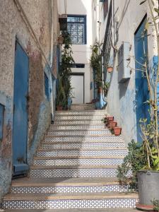 una escalera en un callejón con puertas y plantas azules en Vanila Taghazout, en Taghazout