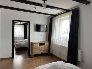 1 dormitorio con cama, tocador y espejo en Hotel Intim, en Rădăuţi