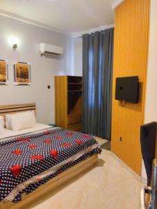 sypialnia z łóżkiem i telewizorem na ścianie w obiekcie MUSAROQ HOTEL w mieście Lagos
