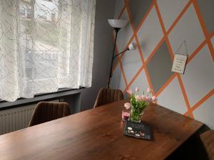 a wooden table with a vase of flowers on it at Appartement in Pommern mit Garten und Grill in Pommern