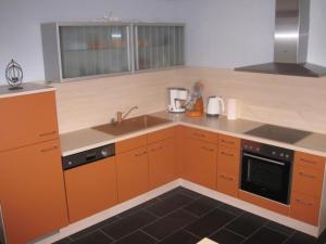 a kitchen with orange cabinets and a sink at Appartement in Pommern mit Garten und Grill in Pommern