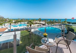 a balcony with a view of a pool and the ocean at Kaya Side in Side