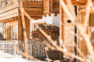 a chair sitting in front of a pile of wood at Birnbaum Chalet Kreuzkogel mit Naturbadesee und eingezäunten Garten in Grossarl