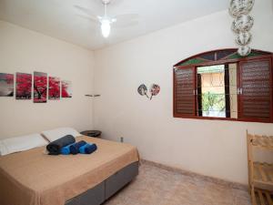 een slaapkamer met een bed met blauwe kussens erop bij Pousada Confraria Casa Branca in Casa Branca