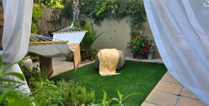 a small garden with artificial grass and a swing at SAGE Cottage Bloubergstrand in Cape Town