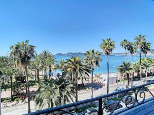 a view of a beach with palm trees and the ocean at Le Croisette I - 4 pers - Front de mer - Cannes in Cannes